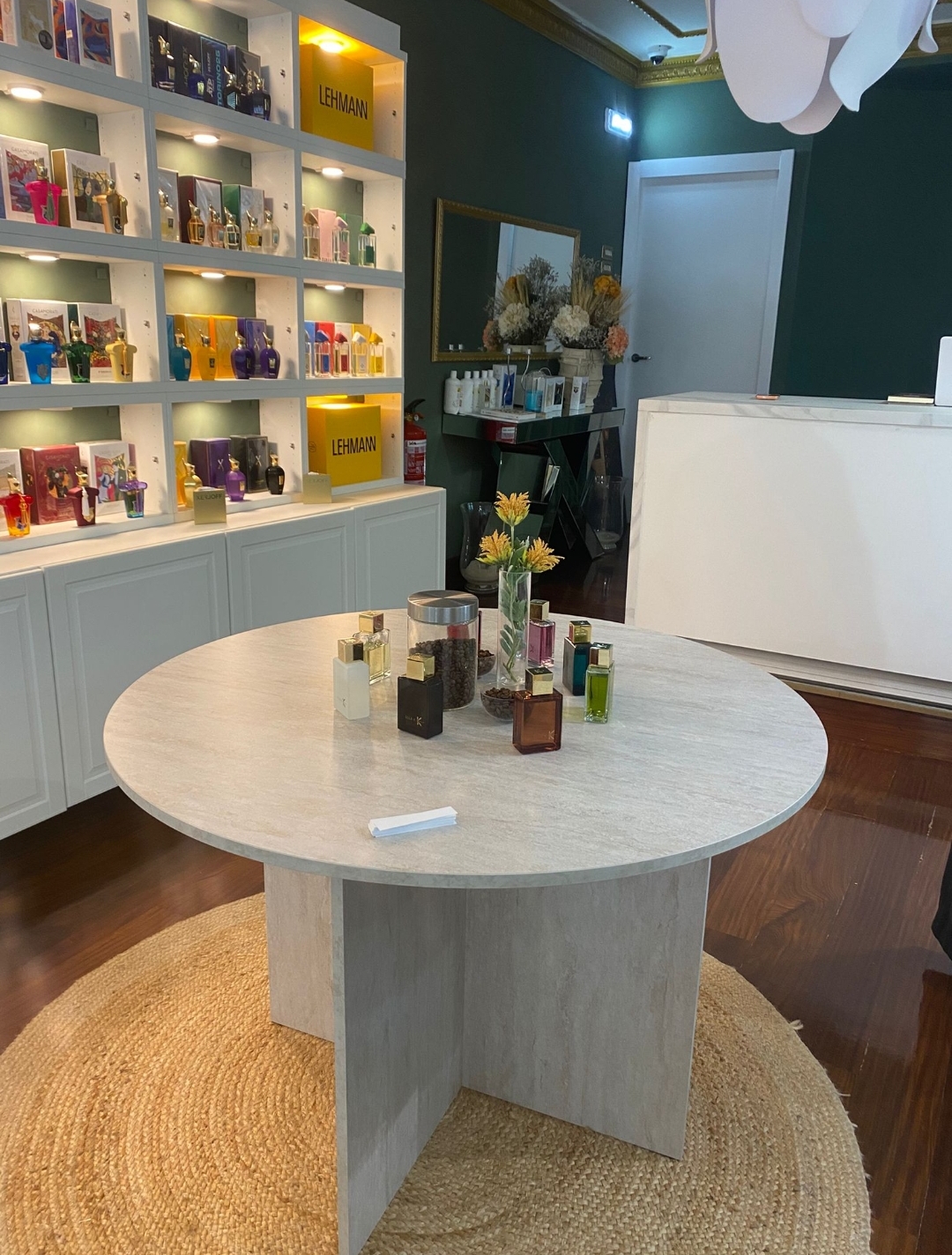 The round marble table at La Maison de Pat, surrounded by perfume shelves